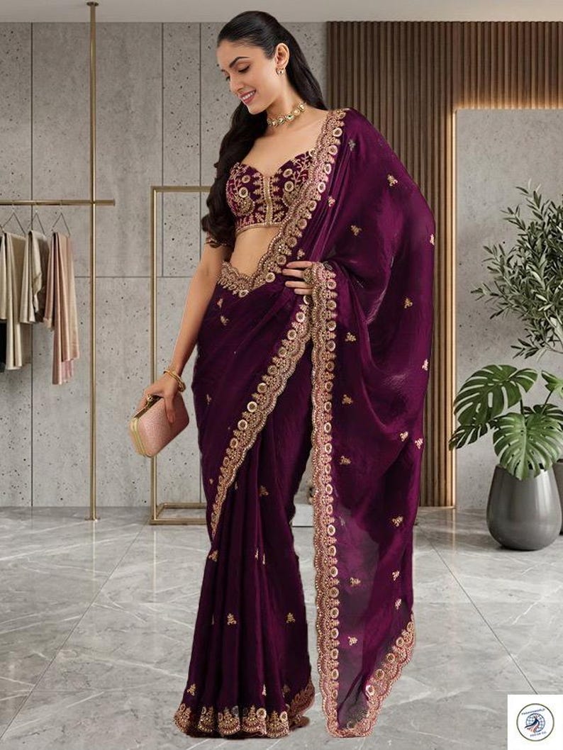 Peut inclure: Un sari violet fonc&eacute; avec des broderies dor&eacute;es complexes sur les bordures et le corsage. Le sari comprend un chemisier assorti avec des ornements dor&eacute;s d&eacute;taill&eacute;s. Une petite pochette rose compl&egrave;te l'ensemble. Le style g&eacute;n&eacute;ral est &eacute;l&eacute;gant et formel.