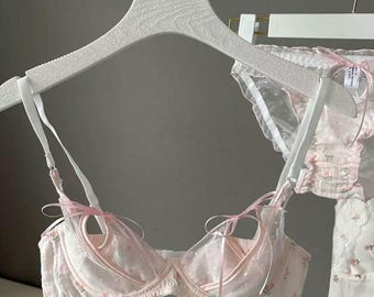 Conjunto de lencería de encaje floral: sujetador y braguita transparentes en rosa suave, lencería romántica y coqueta.