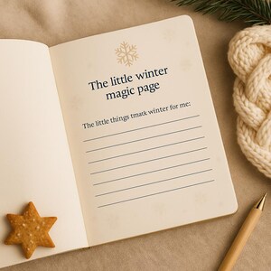May include: Open journal with the text "The little winter magic page" and lined pages. A star-shaped biscuit and a pen are on the table. A knitted item and a sprig of greenery are in the background.