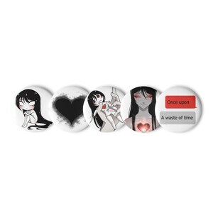 May include: A set of five white round buttons with anime-style illustrations. The designs include a black heart, a sad girl, and text that reads "Once upon" and "A waste of time" in a red and gray speech bubble.
