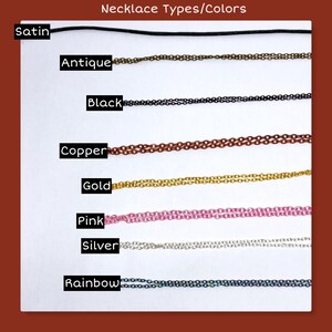 May include: An image showcasing various necklace chain types and colors. The options include satin, antique, black, copper, gold, pink, silver, and rainbow. The text "Necklace Types/Colors" is at the top.