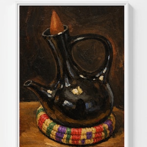 May include: A black ceramic coffee pot with a long spout and a large handle. The pot sits on a colourful, woven coaster. A brown, cone-shaped object is inside the pot. The background is a dark brown.