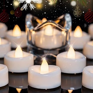 May include: A collection of white LED tea light candles with a warm, flickering glow. A clear glass candle holder is in the center. The background features Christmas ornaments and sparkling lights, creating a festive holiday ambiance.