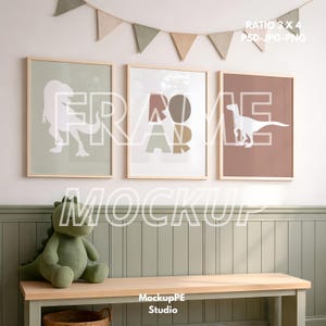 Könnte beinhalten: Drei gerahmte Kunstdrucke mit Dinosauriern in einem Kinderzimmer. Die Drucke zeigen Dinosaurier-Silhouetten und das Wort "ROAR" in neutralen Farben. Ein grüner Stoffdinosaurier sitzt auf einer Holzbank unter dem Kunstwerk.