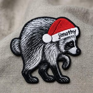 May include: An embroidered patch featuring a black and white raccoon wearing a red and white Santa hat. The white brim of the hat includes the black embroidered text "jimothy". The raccoon is depicted in profile, facing right, with a small tail.