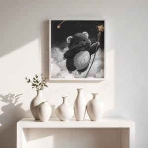 Könnte beinhalten: Schwarz-weiße Illustration eines Hamsters mit einem Sternenstab, der in Wolken schwebt. Das Kunstwerk ist gerahmt und über einem weißen Regal mit mehreren weißen Vasen ausgestellt. Das Gesamtthema ist skurril und künstlerisch.