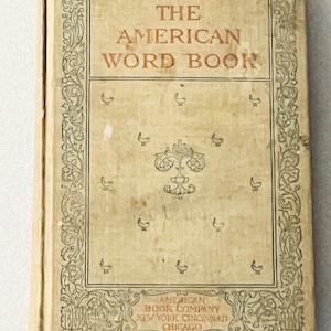 May include: A vintage hardcover book titled The American Word Book with a tan cover featuring a decorative border, a central floral emblem, and small bird motifs. The bottom text reads American Book Company, New York, Cincinnati, Chicago.
