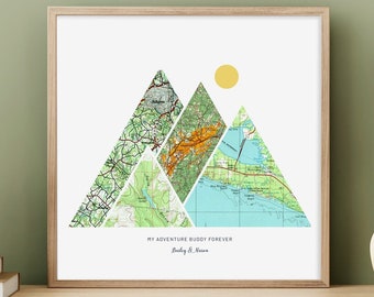 May include: A framed print with a mountain range design made from maps. The mountains are made from different colored maps, and the sun is a yellow circle. The text at the bottom reads "My Adventure Buddy Forever" and "[Name] & [Name]"