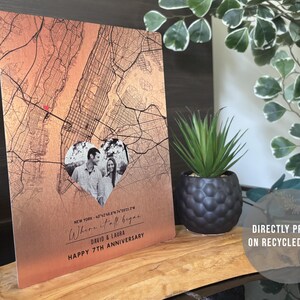 May include: A copper-colored metal print with a map of New York City. A heart-shaped photo of a couple is in the center of the map. The text "Where it all began..." is written below the photo. The text "David & Laura" and "Happy 7th Anniversary" is written below the map. The print is directly printed on recycled metal.