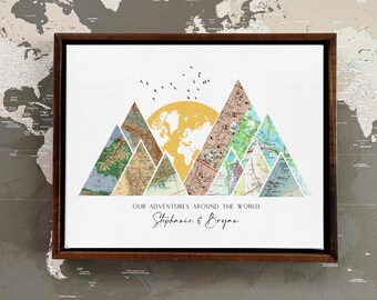May include: A framed print with a white background featuring a collage of maps forming a mountain range with a yellow sun and the text "Our adventures around the world Stephanie & Bryan".