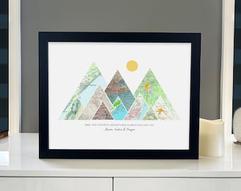 May include: A framed print with a mountain range made of maps. The mountains are in shades of blue, green, and brown. The text below the mountains reads "Dad, our favorite adventures always include you.  Mason, Caden & Taygan".