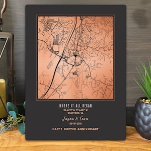 May include: A rectangular wall plaque featuring a copper-colored map with black street lines. Below the map, the text reads: WHERE IT ALL BEGAN, 38.4217 N, 77.4217 W, STAFFORD, VA, Jason & Tara, 08-18-2019, HAPPY COPPER ANNIVERSARY.
