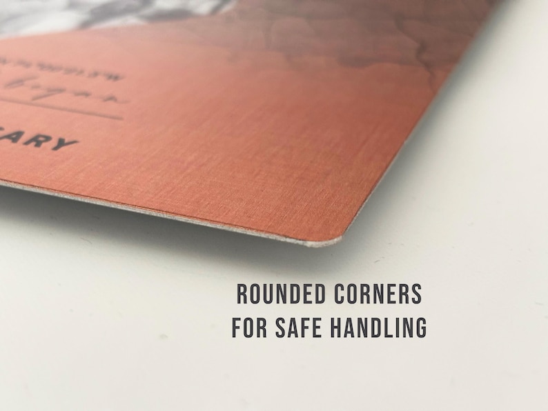 May include: Close-up of the corner of a red-brown metal sign with rounded edges. The text "ROUNDED CORNERS FOR SAFE HANDLING" is printed in black below the sign.