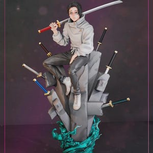 May include: A detailed figurine of a character from an anime series. The figure is dressed in a white jacket and black pants, holding a large sword. The figure is seated on a gray stone structure with several swords embedded. The base features a teal, wave-like design.
