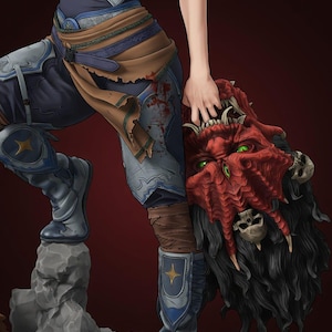 Pode incluir: Uma estatueta de fantasia detalhada apresentando um guerreiro em armadura azul e prata com tecido manchado de sangue, em uma base rochosa. A figura segura uma cabeça de monstro vermelha decepada com olhos verdes, dentes afiados e crânios.