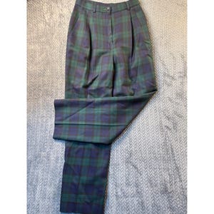May include: Green and navy plaid trousers with a button closure and pleats. The pants are made of a woven fabric and have a classic, tailored style. The plaid pattern is a traditional design.
