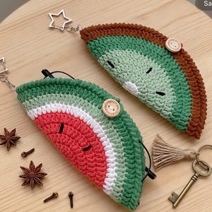 May include: Two handmade crochet eyeglass cases shaped like watermelon slices. The cases feature red, green, and white yarn, with wooden button closures and star-shaped keychains. The cases are approximately 7 inches long.
