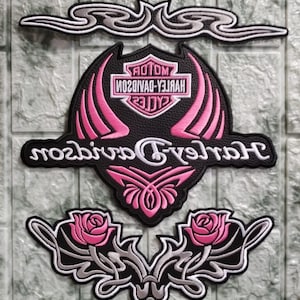 Może przedstawiać: Haftowane naszywki Harley-Davidson w kolorach czarnym, różowym i srebrnym. Zestaw zawiera duże logo tarczy z nazwą marki, ozdobny element górny oraz dwa wzory róż. Naszywki przeznaczone są do nakładania na odzież lub akcesoria.