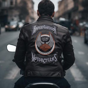 Puede incluir: Chaqueta de moto de cuero negro con parches Harley-Davidson. La chaqueta presenta el logotipo de Harley-Davidson y las palabras "MOTORCYCLES" y "105 years" en la espalda. La chaqueta la lleva una persona montada en una moto en una calle de la ciudad.