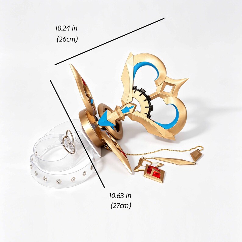 May include: A gold-coloured prop key, 26cm long, with blue accents and a gear-like centre. A clear belt with a heart-shaped buckle is also present. The key has a red and gold pendant attached by a chain. The key is a cosplay item.