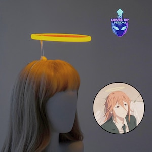 May include: A luminous yellow halo, attached to a mannequin head with blonde hair. The halo is circular and glows brightly. A circular graphic features an anime character with a halo. The text "LEVEL UP PERSONA" is also visible.