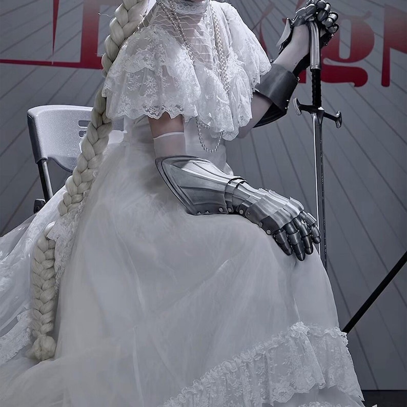 May include: A white dress with lace detailing and a long, thick braid. The person is wearing silver metal gauntlets and holding a sword. The background is a light gray with red text.