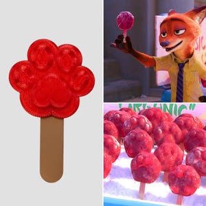 Może przedstawiać: Czerwony lizak w kształcie łapy na brązowym patyku. Na zdjęciu widać również lisa z kreskówki trzymającego podobnego lizaka oraz ekspozycję wielu lizaków w kształcie łapy.