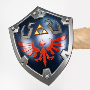 May include: A blue and silver shield with a red bird emblem and gold triangles. The shield has a silver border and rivets. The shield is held by a person.