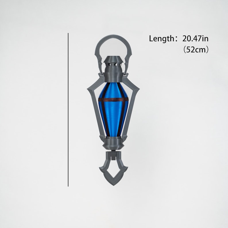May include: A grey and blue decorative lantern, 52cm long. The lantern features a blue, teardrop-shaped centre with grey accents and a handle at the top. The base has a decorative, pointed design.