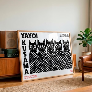 May include: A rectangular framed art print featuring five black cats with large white eyes and white polka-dot bodies. The text reads YAYOI KUSAMA, MUSEE D ART MODERNE DE LA VILLE DE PARIS, TOKYO 1995, and Japanese characters in the upper right corner.
