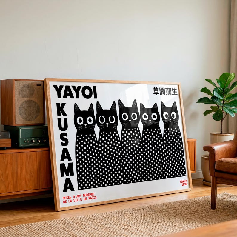 May include: A rectangular framed art print featuring five black cats with large white eyes and white polka-dot bodies. The text reads YAYOI KUSAMA, MUSEE D ART MODERNE DE LA VILLE DE PARIS, TOKYO 1995, and Japanese characters in the upper right corner.