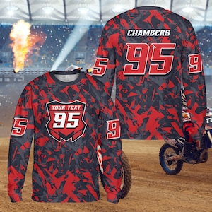 May include: Long-sleeved motocross jersey with a red and gray abstract pattern. The jersey features the number 95 in white with a red outline, and the name "CHAMBERS" is printed on the back. The sleeves have the numbers 5 and 9.