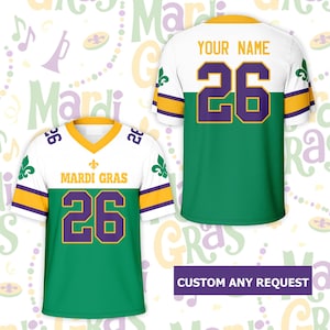 May include: White, green, and gold Mardi Gras jersey with the number 26 in purple. The front of the jersey reads "MARDI GRAS" and has a fleur-de-lis design. The back of the jersey has the text "YOUR NAME". The jersey is a custom design.