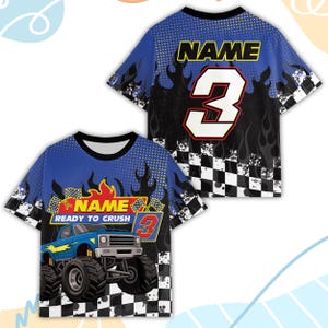 Peut inclure: T-shirt bleu et noir &agrave; manches courtes avec un motif de monster truck. Le t-shirt porte l'inscription "NAME READY TO CRUSH" et le chiffre "3". Le motif comprend des flammes et un motif de drapeau &agrave; damier.