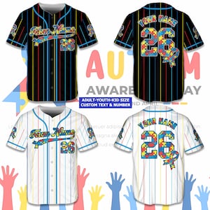 May include: Baseball jerseys with vertical stripes in black and white, featuring the text "Team Name" and the number "26". The jerseys have a colourful puzzle piece design and the text "Autism Awareness Day".