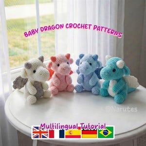 May include: Four crocheted baby dragons in various colors: white, pink, light blue, and turquoise. Each dragon has wings and horns. The image includes the text "Baby Dragon Crochet Patterns" and "Multilingual Tutorial".
