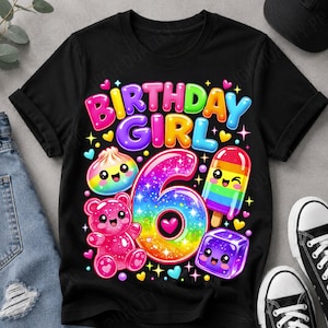 Może przedstawiać: Czarna koszulka z kolorową grafiką przedstawiającą napis "BIRTHDAY GIRL" w formie bąbelkowych liter nad dużą tęczową cyfrą 6. Wzór zawiera uśmiechniętego pierożka, różowego żelkowego misia, tęczowego loda na patyku oraz fioletową kostkę lodu.