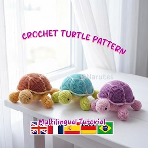 Könnte beinhalten: Drei gehäkelte Schildkröten in Braun-, Türkis- und Lilatönen sitzen auf einer weißen Oberfläche. Die Schildkröten haben detaillierte Schalenmuster. Der Text "CROCHET TURTLE PATTERN" und "Multilingual Tutorial" ist sichtbar.