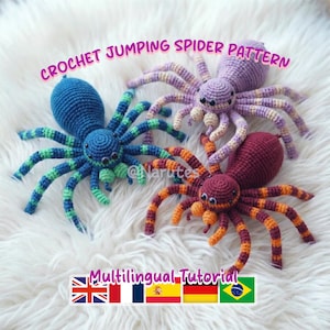 Puede incluir: Tres arañas saltarinas de ganchillo en azul, morado y burdeos con patas a rayas. Las arañas están sobre una superficie blanca y esponjosa. El texto en la parte superior dice "CROCHET JUMPING SPIDER PATTERN".