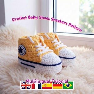 May include: Hand-crocheted baby sneakers in yellow and white. The shoes have a star emblem and white laces. The text "Crochet Baby Shoes Sneakers Pattern" is displayed. The shoes are on a fluffy surface.