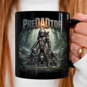 May include: Black ceramic mug featuring a Predator-themed design with the text "PREDADDTOR". The design includes a Predator figure with smaller figures and names. The background depicts a jungle scene.