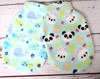 May include: Two blue fleece hot water bottle covers. One features a whale and sea life pattern, the other features pandas and bunnies.