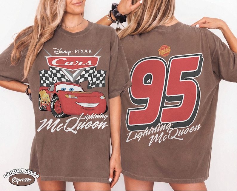 Może przedstawiać: Brązowa koszulka z Lightning McQueen z filmu Auta Disneya Pixara. Prz&oacute;d przedstawia logo Auta, szachownicę i Lightning McQueen. Tył ma duży czerwony numer 95 i napis Lightning McQueen.