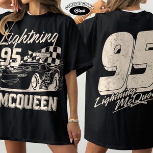 May include: Black Lightning McQueen t-shirt with a distressed graphic of the race car and the number 95. The front of the shirt features the text "Lightning McQueen" and "95". The back of the shirt has a large "95" and "Lightning McQueen" text.