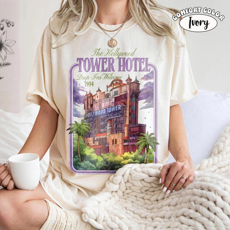Op de afbeelding: Ivoor kleurig T-shirt met een afbeelding van het Hollywood Tower Hotel met de tekst "The Hollywood Tower Hotel Drop-Ins Welcome 1994". Het shirt is van het merk Comfort Color.