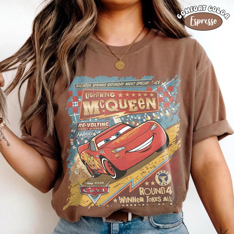 May include: Brown t-shirt featuring a graphic of Lightning McQueen from the Disney Pixar Cars movie. The design includes the text "Lightning McQueen," "Radiator Springs," and "Round 4 Winner Takes All." The shirt is labeled "Comfort Color Espresso."