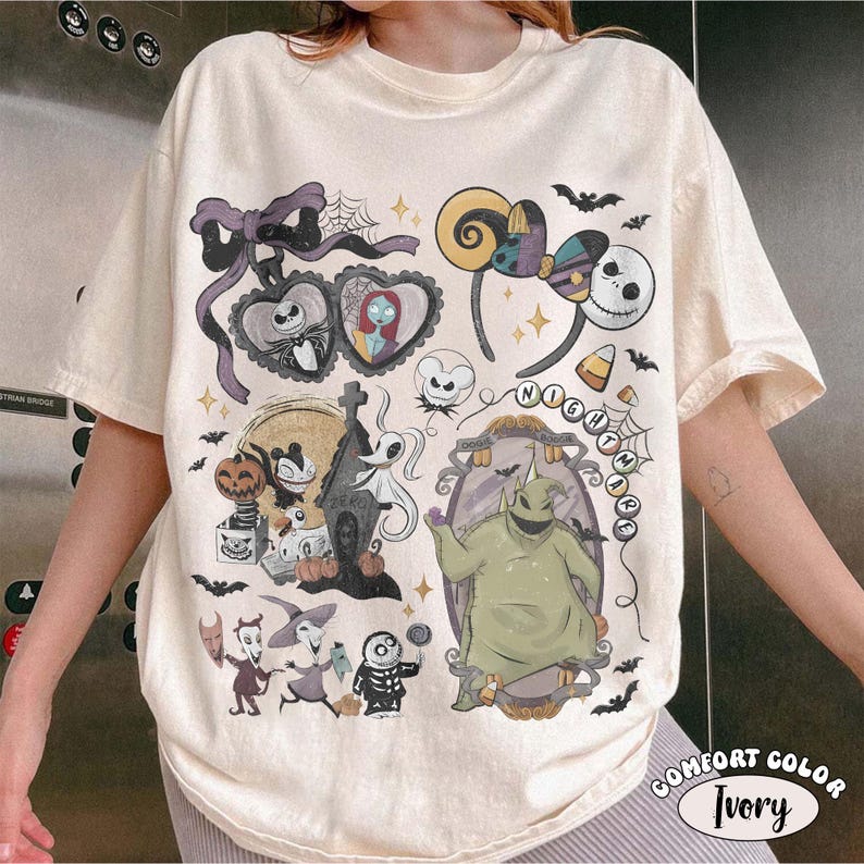 May include: An ivory t-shirt featuring a graphic print of characters and icons from The Nightmare Before Christmas, including Jack Skellington, Sally, Oogie Boogie, and Zero, surrounded by bats, spiderwebs, and decorative frames in various colors.