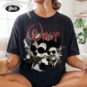 Puede incluir: Camiseta negra Comfort Colors con un gr&aacute;fico de Mickey Mouse con gafas de sol y Walt Disney. La palabra "Walt" est&aacute; en escritura roja encima de la imagen. La camiseta es de estilo vintage.