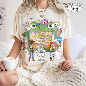 Puede incluir: Una camiseta de manga corta color marfil con un estampado gr&aacute;fico de varios personajes animados que rodean un marco verde con forma de rana. El texto dentro del marco dice I KNEW IT I KNEW YOU WE'RE TURNING 5. Se ve una etiqueta Comfort Color Ivory.