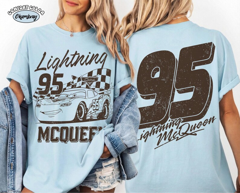 May include: Light blue t-shirt featuring a graphic of Lightning McQueen from the movie Cars. The front design includes the text "Lightning 95 McQueen" with an image of the race car. The back of the shirt displays a large "95" and "Lightning McQueen".